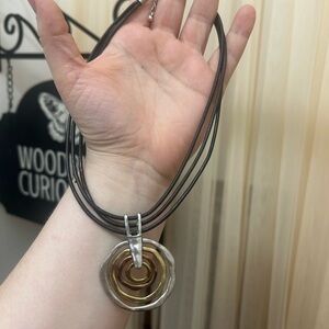 Multi strand leather necklace with mixed metal circle pendant